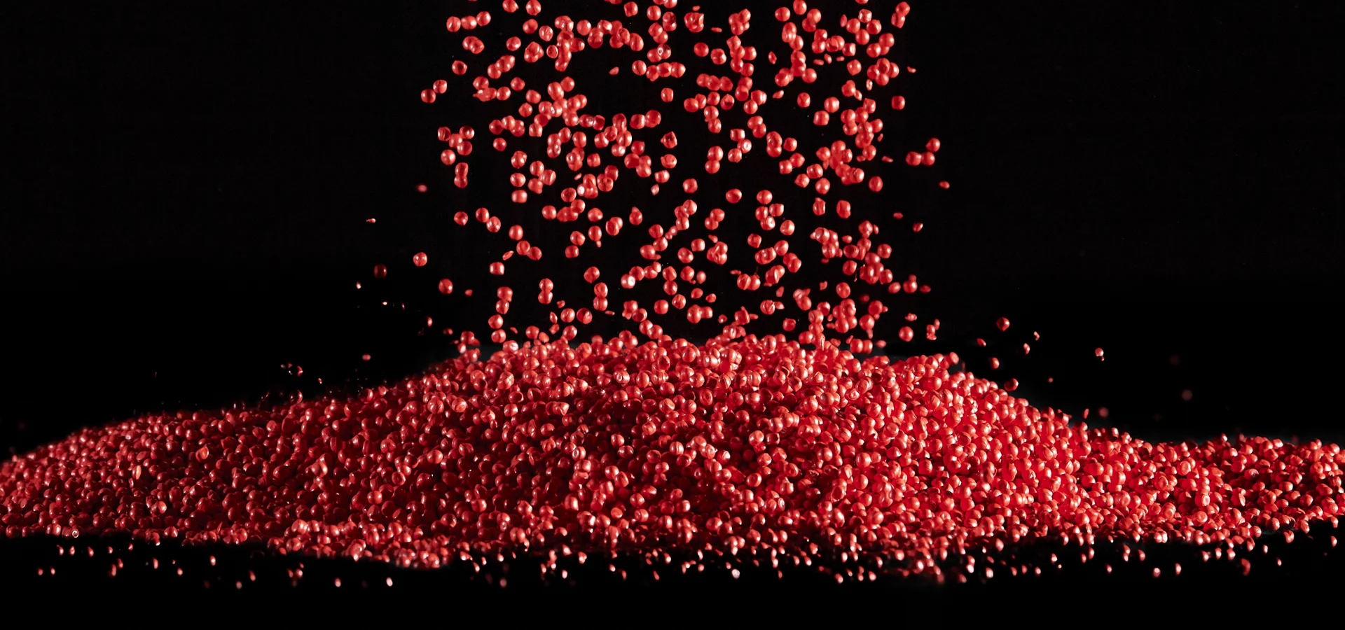 rotes-plastik-granulat Red flowing plastic granules