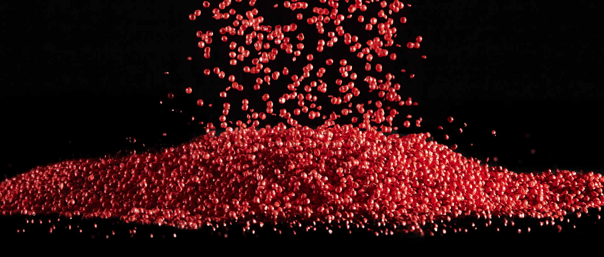 rotes-plastik-granulat Red flowing plastic granules